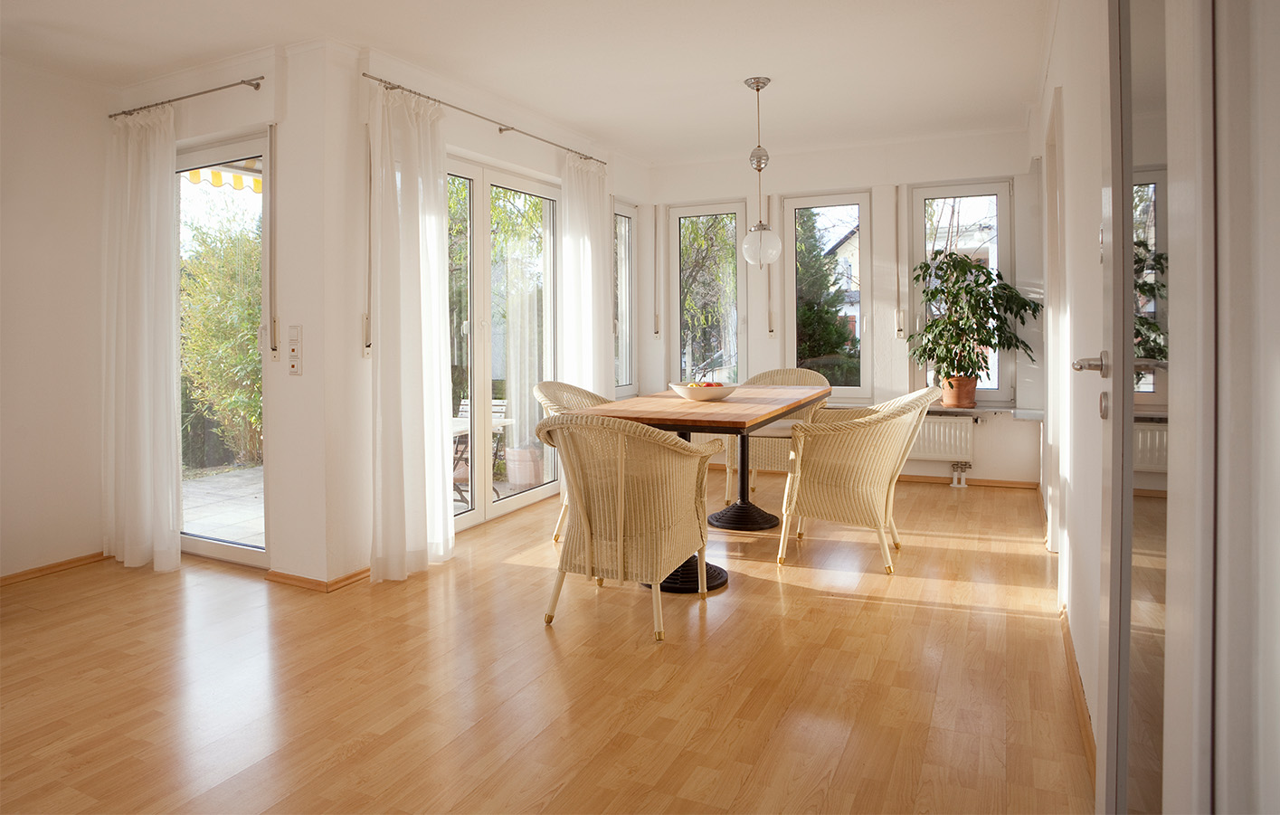 Wohnbereich mit Esszimmer und großer Fensterfront, die viel Licht in den Raum bringt.